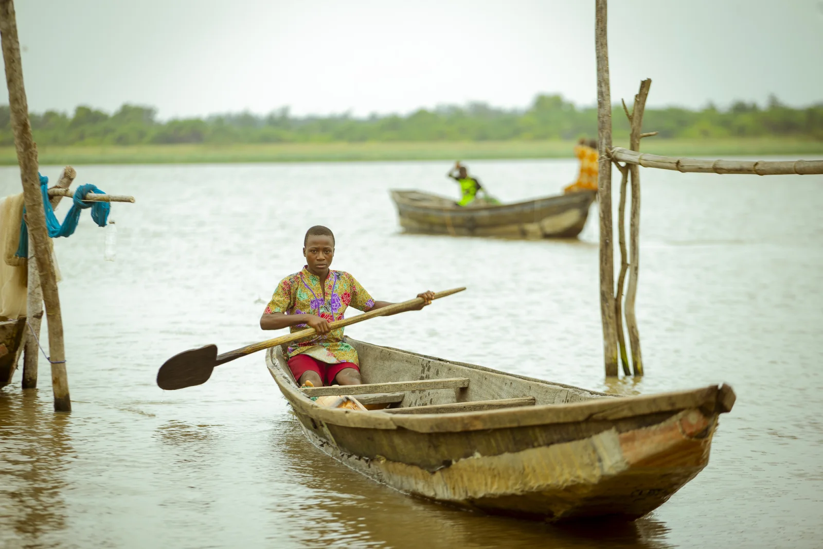 A young person paddling a canoe in Badagry
